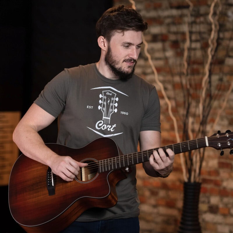 Man playing acoustic guitar in a music shop in Swords, Dublin.