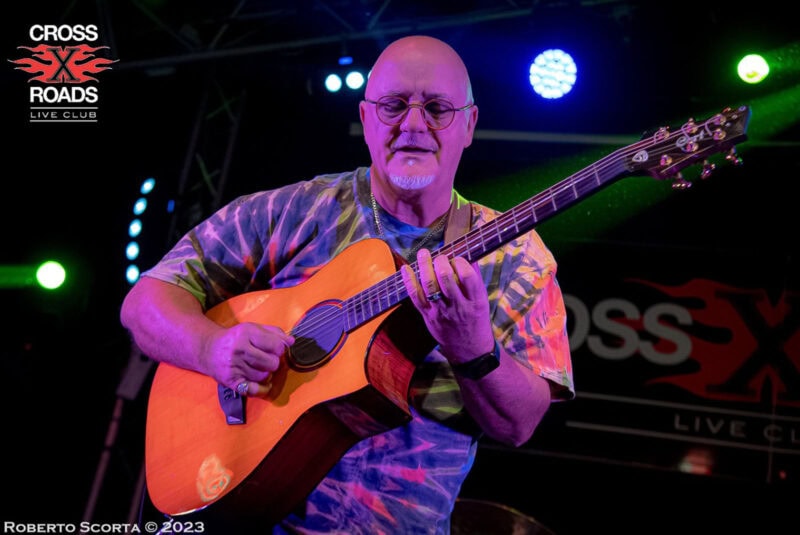 Guitarist performing live at Cross Roads Live Club in Swords, Dublin, illuminated by colourful stage lights, capturing a vibrant music scene.