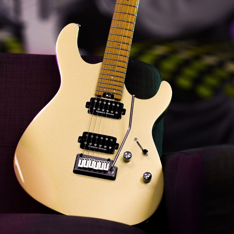 Electric guitar on a dark green seat at The Music Outlet in Swords, Dublin. Featuring Seymour Duncan pickups, a cream finish, and a tremolo bridge, perfect for musicians of all levels.